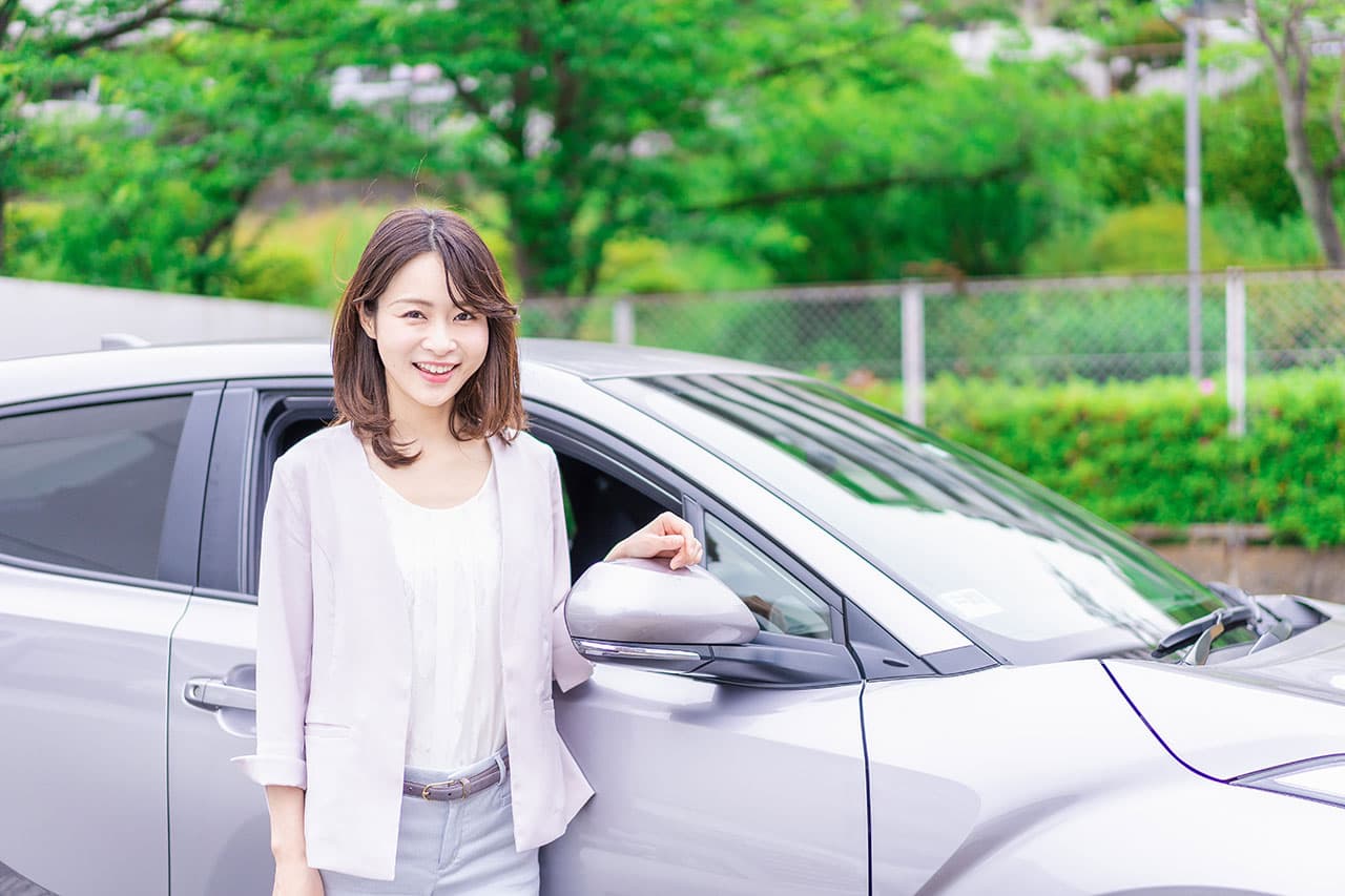 車の前で笑顔の女性