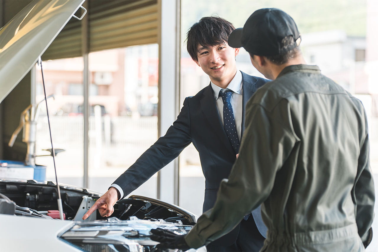 車の確認を整備士さんと男性がしている様子